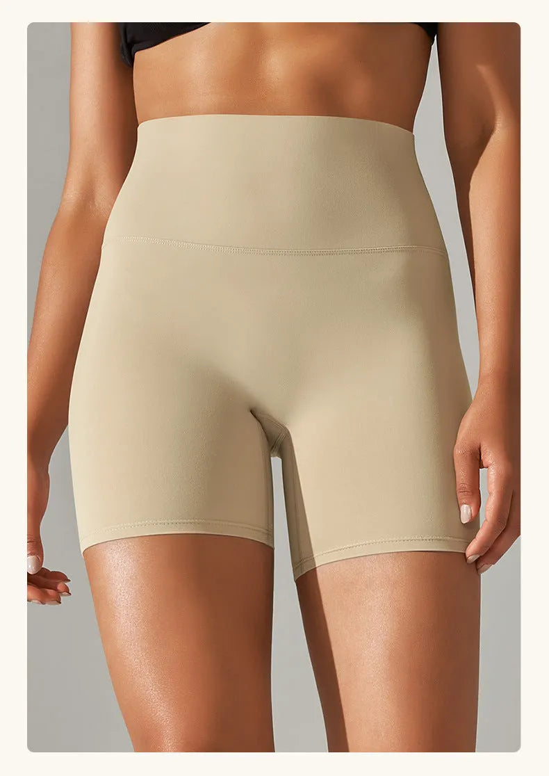 Woman wearing high waist hip lift fitness tights in a neutral colour, suitable for running or gym workout.