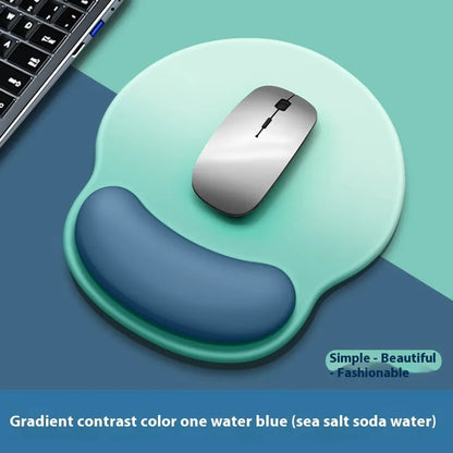 Silicone mouse mat with wristband in a gradient blue black colour pattern on a desk.