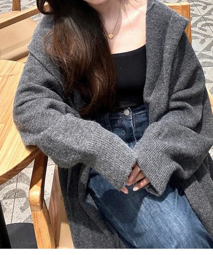 Women's Korean style hooded long knitted cardigan in oatmeal colour, showing loose fit and below-the-knee length
