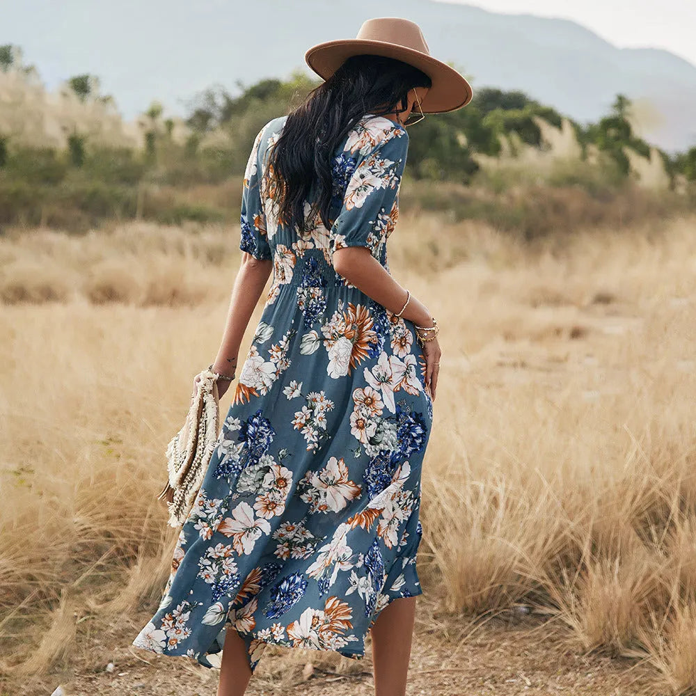 Yellow floral print women's dress with V-neck, short sleeves, elastic waist, and a large hemline midi skirt.