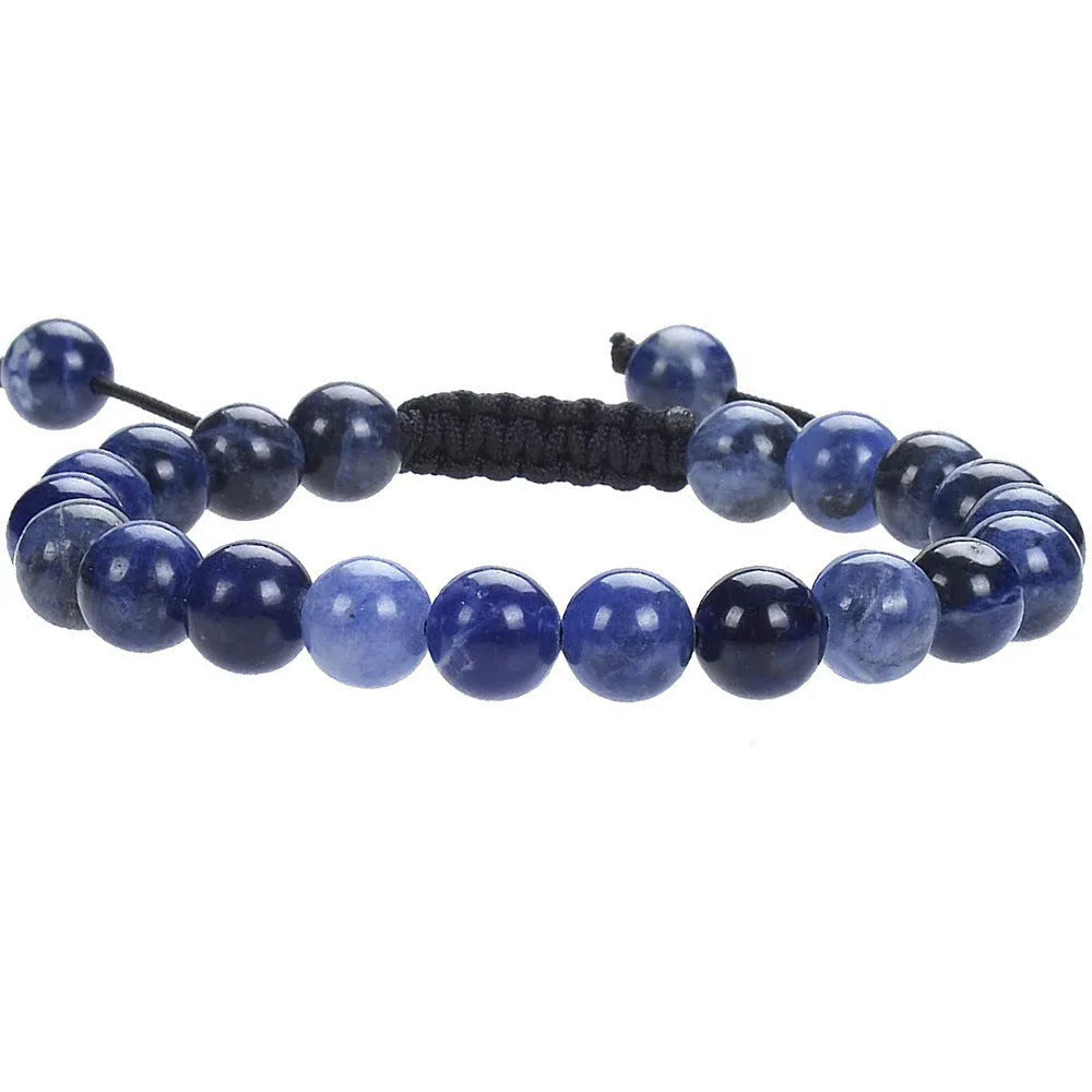 Close-up of a women's flat knot braided healing bracelet hand-woven with colourful gemstones.