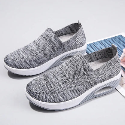 Women's beige mesh running shoes with round toe and air cushion midsole on a grey background.