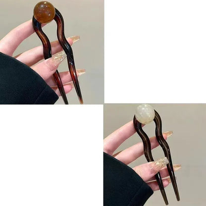 Acrylic U-shaped hair barrette with retro ball design in caramel colour