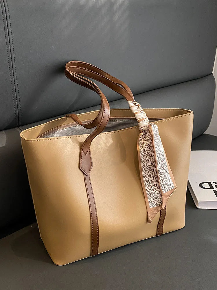 Soft large-capacity bucket tote bag with shoulder strap and zip pocket, shown in a neutral colour.