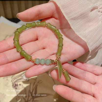 Chinese style glass bead bracelet with bamboo joint design on wrist.