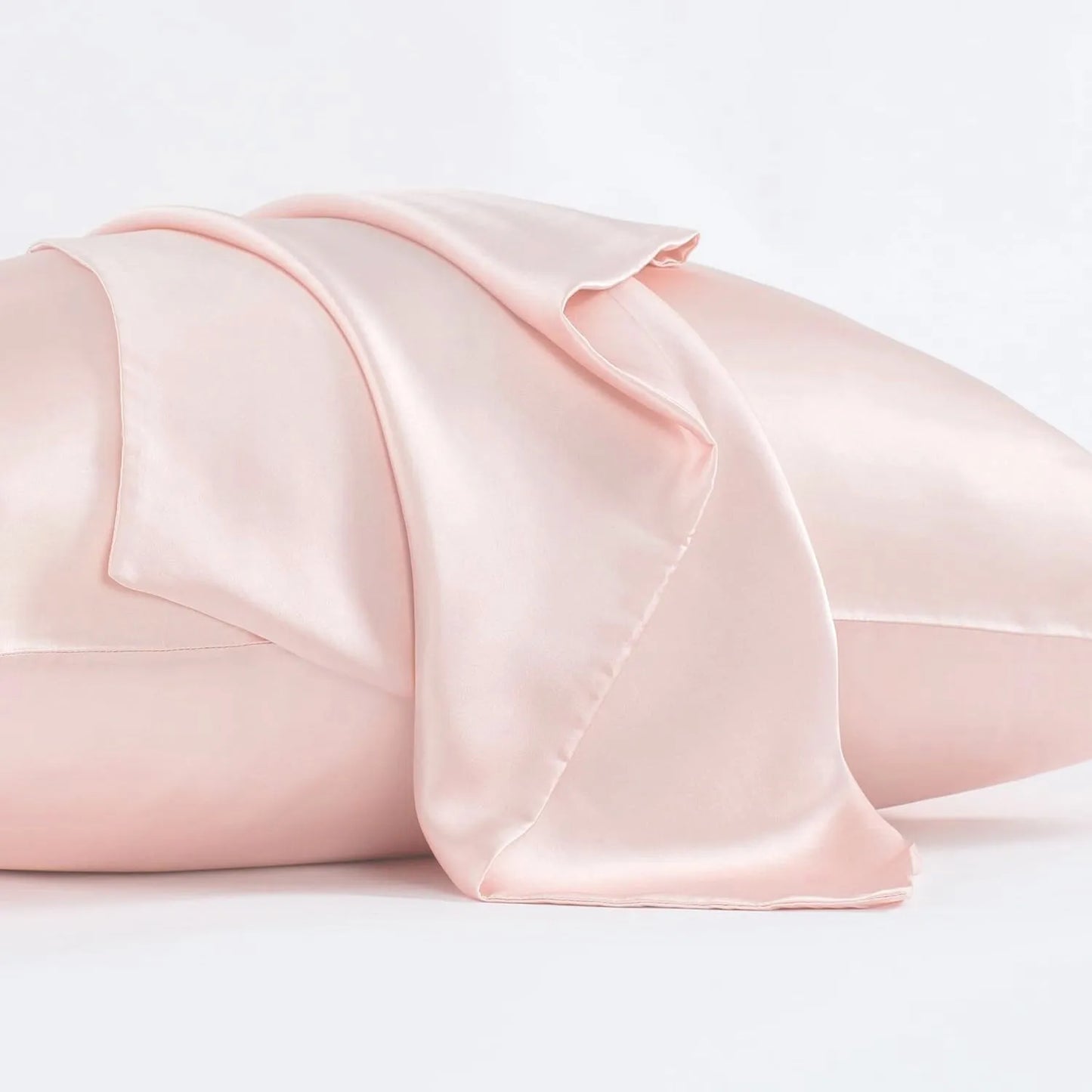 Dark grey silk pillowcase with envelope closure on a bed.