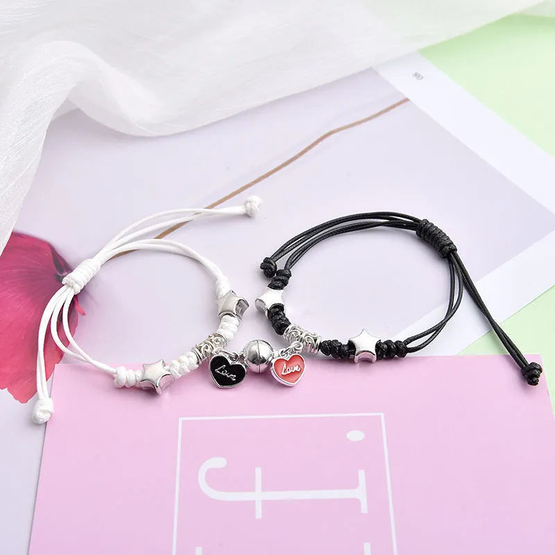 Magnetic suction couple bracelet pair in alloy with an electroplated finish, showing example designs like a crown and love lock.