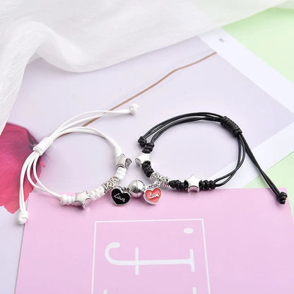 Magnetic suction couple bracelet pair in alloy with an electroplated finish, showing example designs like a crown and love lock.