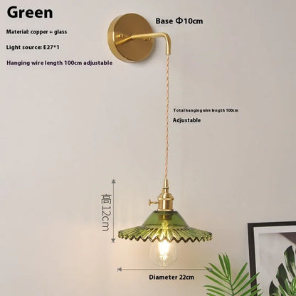 Retro brass lotus wall lamp with copper body and glass shade in various colours, mounted on a wall