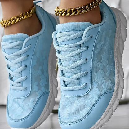 Women's canvas sports shoes in white with round toe and flat heel design on a light background