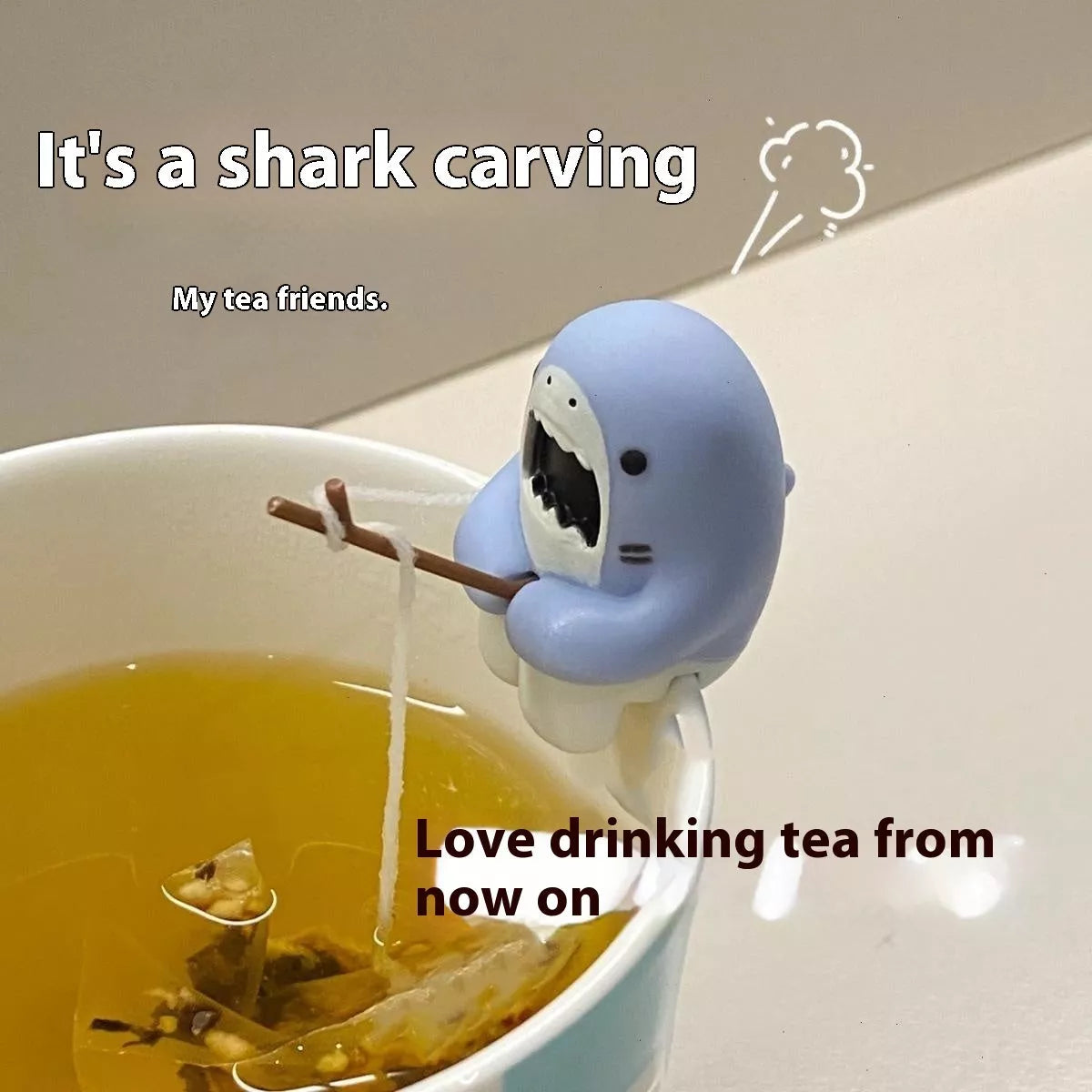 Shark-shaped tea infuser hanging on cup edge, made from food-grade silicone