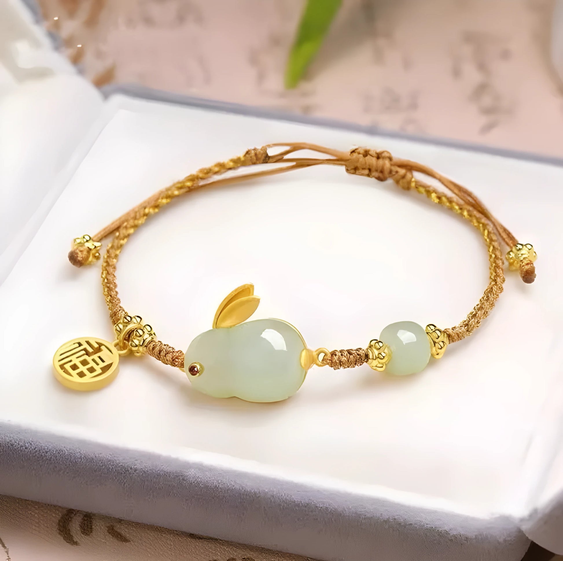 Hetian jade geometric rabbit charm on a yellow string bracelet for women.