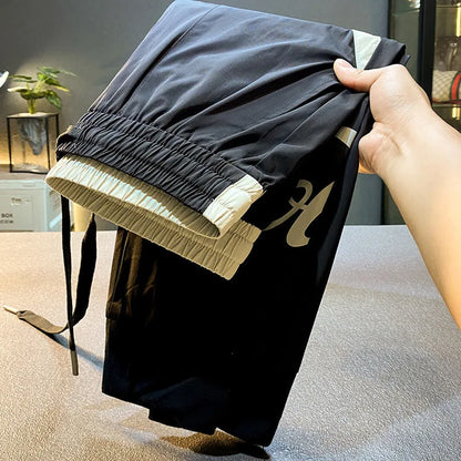 Black men's casual cotton trousers with a cropped, ankle-banded leg design on a neutral background.