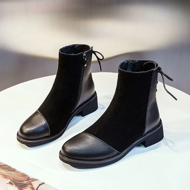 Women's black knee-length Martin boots with side zipper, non-slip rubber sole, and bow detail on microfiber upper