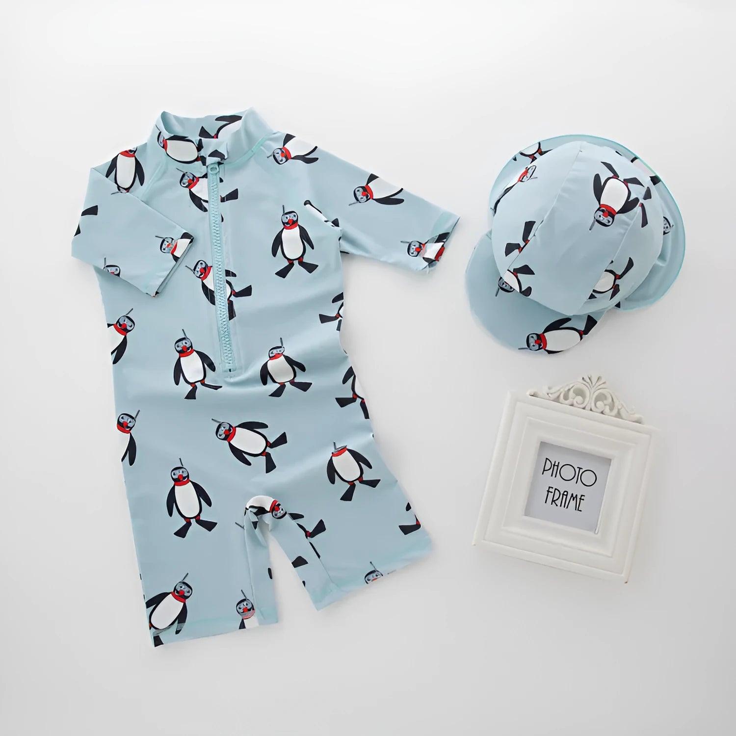 Boy's penguin print long sleeve swimsuit with matching cap for sun protection during water activities