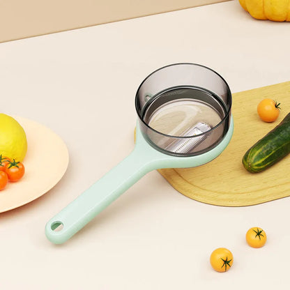 Light green kitchen peeler with an integrated storage bucket for collecting fruit and vegetable peel.