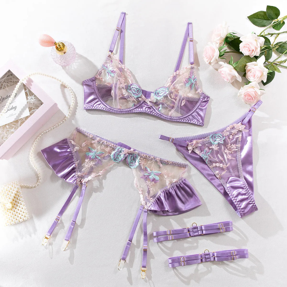 Light purple satin four-piece lingerie set with embroidery on a hanger