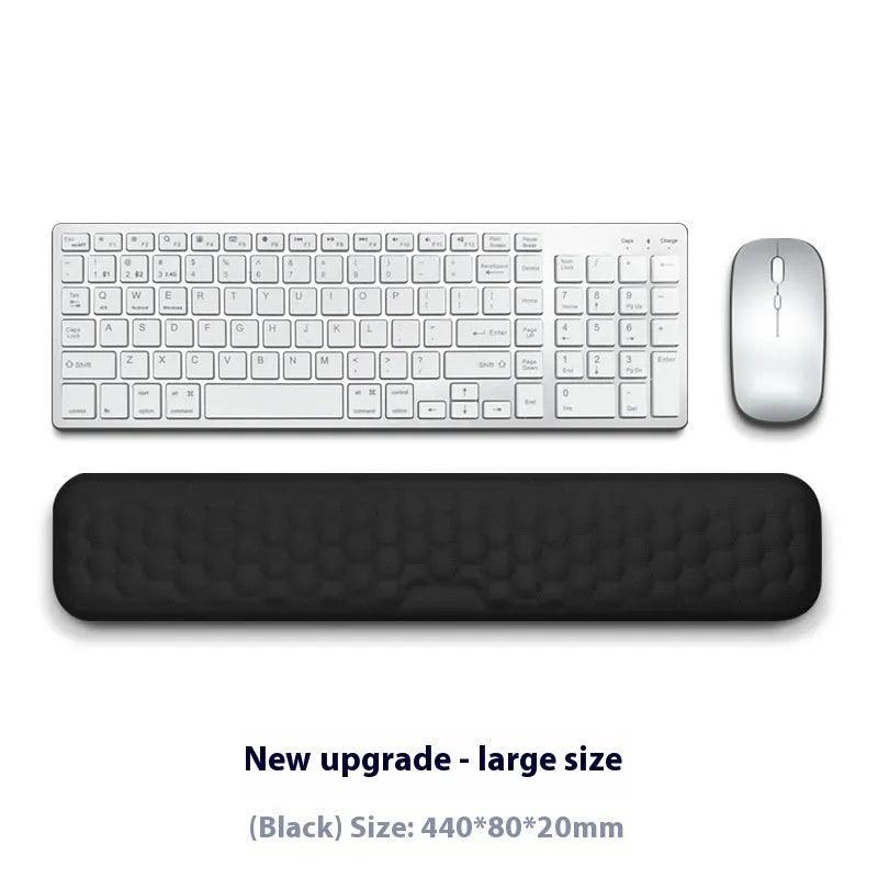 Black and grey memory foam mouse wrist rests with cloth and leather-style covers on a desk.