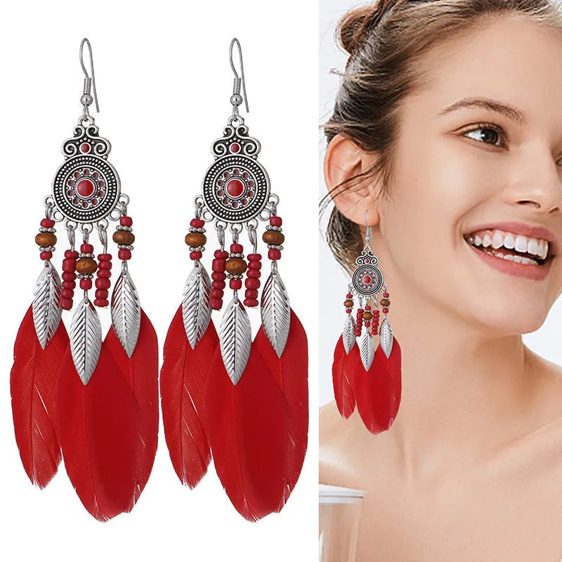 Bohemian feather leaf pattern alloy earrings in round drop shape on a colour selection background.