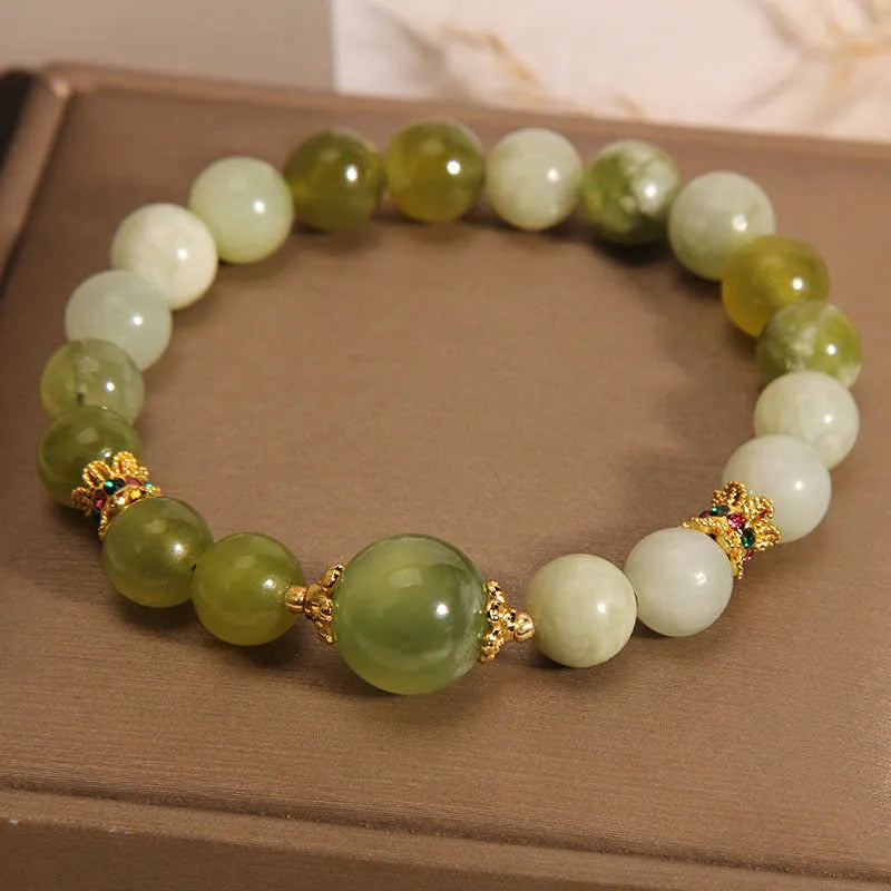 Original design women's bracelet with a green Xiuyan jade stone on wrist.