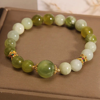 Original design women's bracelet with a green Xiuyan jade stone on wrist.
