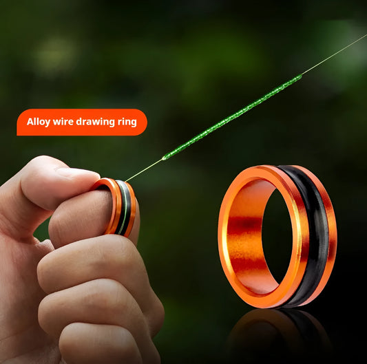 Orange and silver alloy non-slip fishing hand guard pull loop tool on a tackle box.