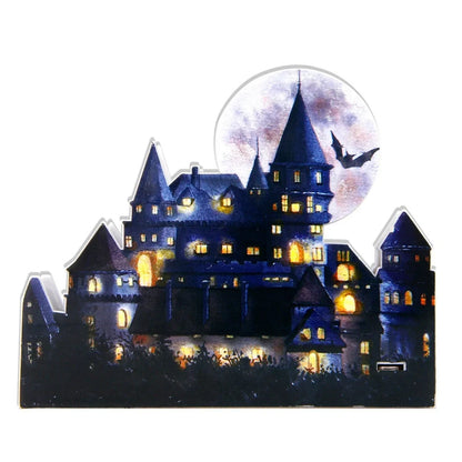 LED illuminated castle ornament with turrets and textured surfaces on desktop