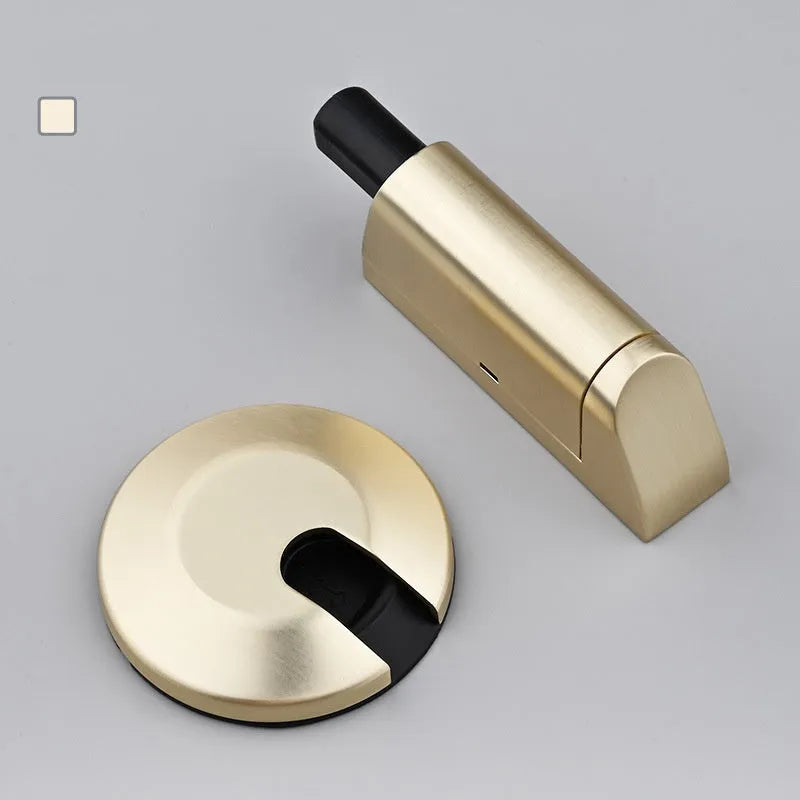 A modern invisible door stopper made from zinc alloy in a brushed gold finish.