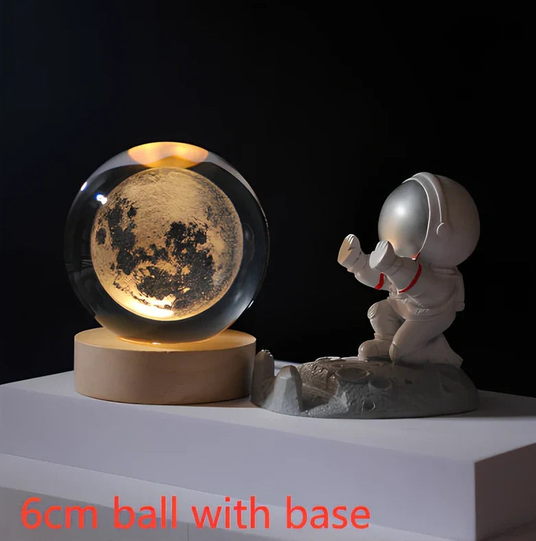 3D crystal ball night light projecting solar system pattern on wooden base with astronaut figurine