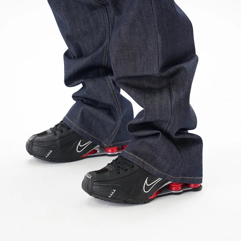 Man wearing dark blue loose-fit straight-leg denim jeans, showcasing the casual relaxed silhouette.