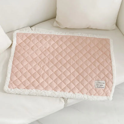 Quilted terry cloth pet blanket for cats in blue, grey, pink, or yellow colour on a pet bed.