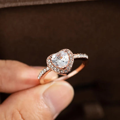 Women's heart-shaped crystal wedding ring in rose gold or silvery on a white background.