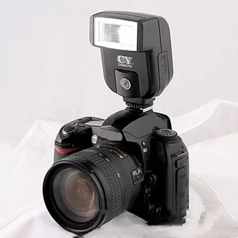 Compact black SLR camera flash unit with head tilted upwards, showing hot shoe mount.