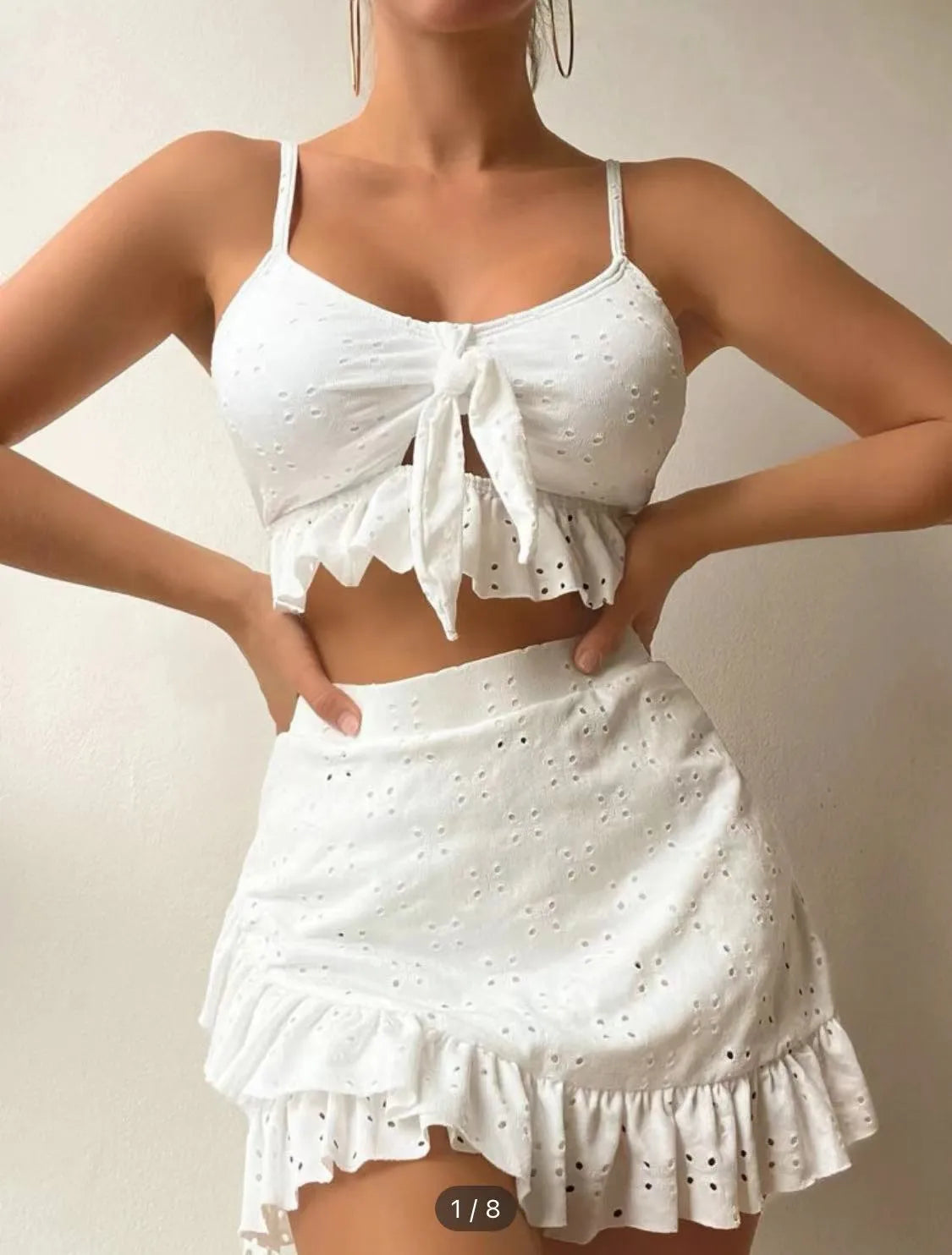 Women's white split hip skirt three-piece bikini swimsuit set on a mannequin.