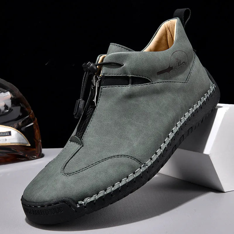 Men's black casual leather shoes with a mid heel, round toe, and visible stitching on a wooden floor.