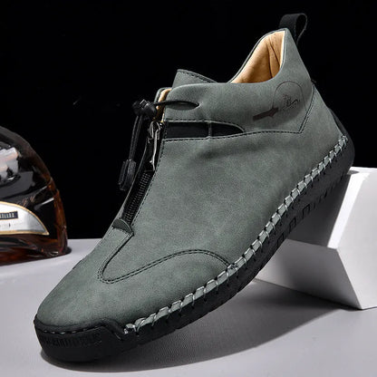 Men's black casual leather shoes with a mid heel, round toe, and visible stitching on a wooden floor.