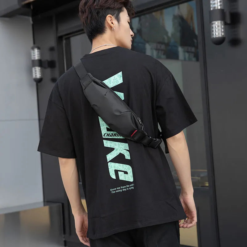 Black Oxford cloth waist pack measuring 12cm high by 27cm wide with crossbody strap and zipper closure