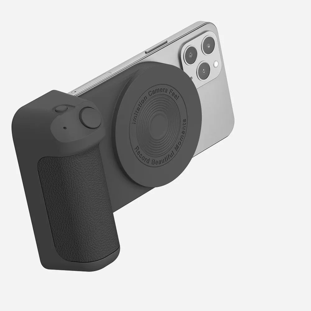 Black magnetic phone camera grip holder with rotatable stand on a table next to a smartphone.