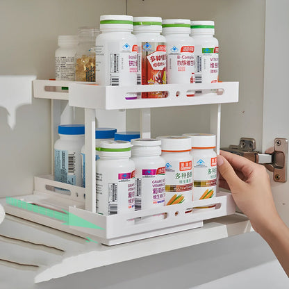 Pull-out spice rack installed under kitchen sink with spices organised in plastic drawer