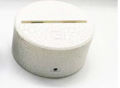 Modern white lotus-shaped LED night light with touch control on a wooden surface.