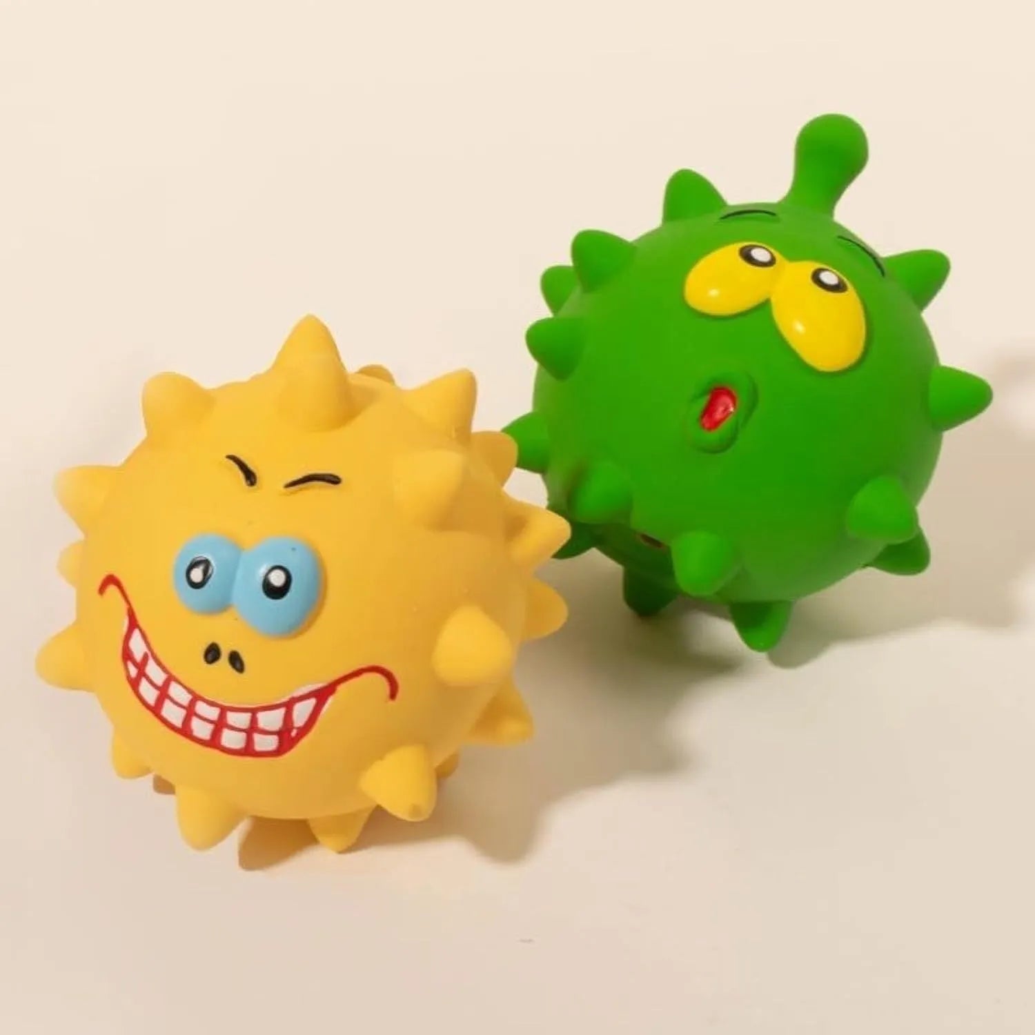 Four coloured natural latex dog balls with textured surfaces and cute faces, each measuring 7.5cm in diameter