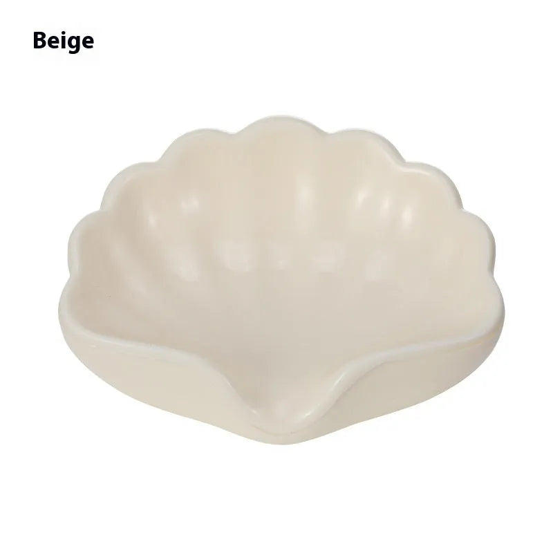 Plastic shell soap dish in pearl white, dimensions 12x9x5.5cm, on a bathroom counter
