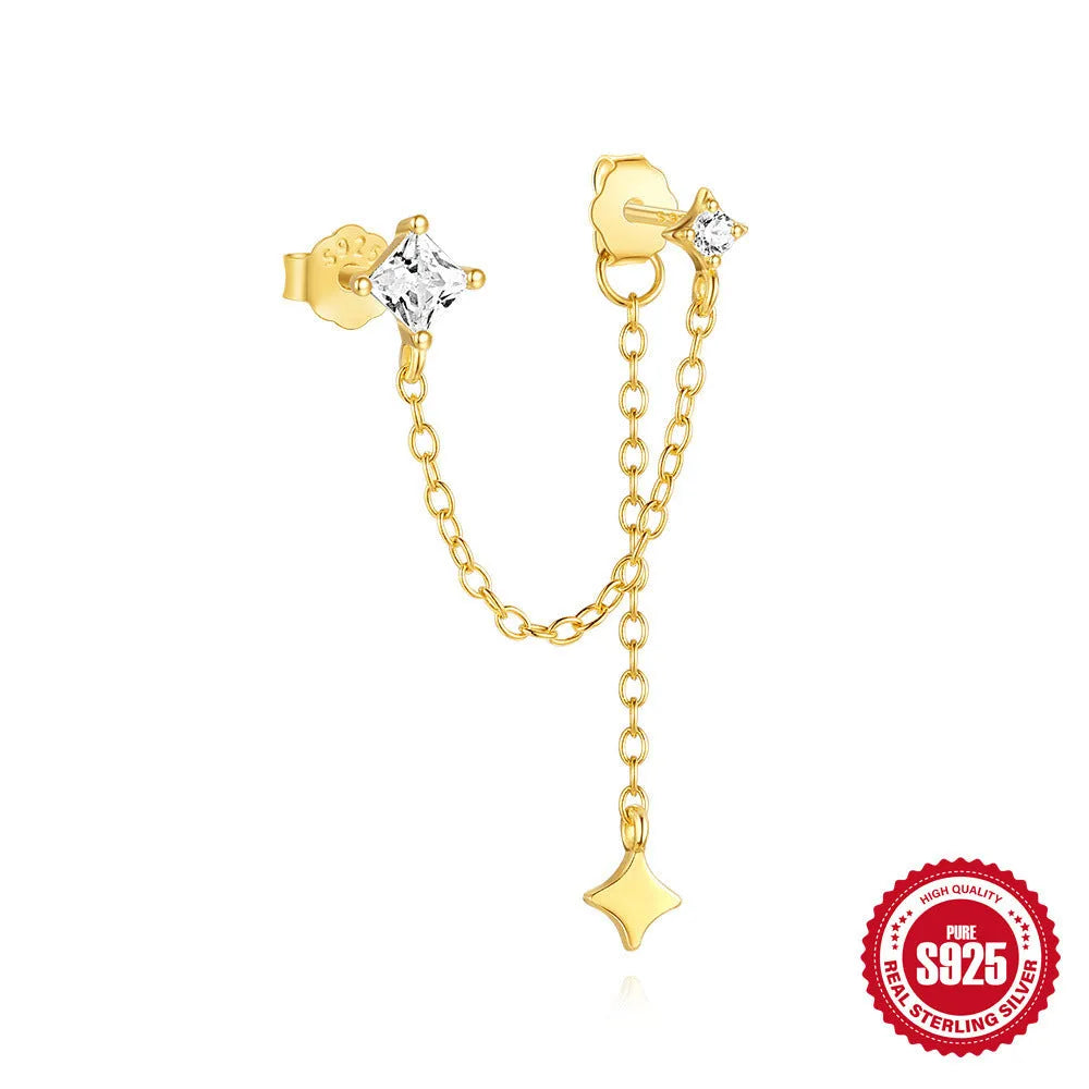 A pair of small golden-toned sterling silver stud earrings with inlaid zircon stones, featuring a delicate chain and clover design.