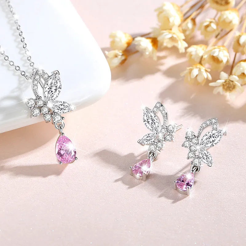 Butterfly shaped silver stud earrings with crystal details on white background