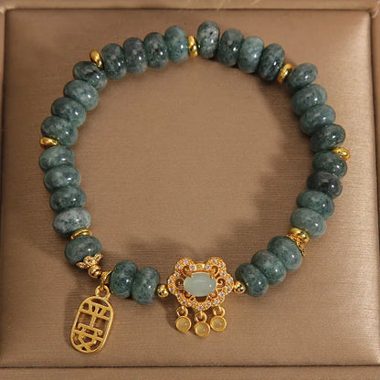 Close-up of a women's bracelet with green emerald jade abacus beads and a silver alloy safety lock clasp.