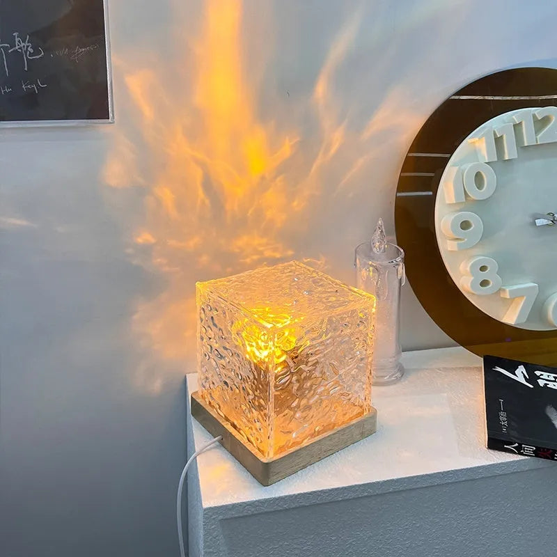 LED water ripple projection night light with remote control on wooden base showing colourful light patterns