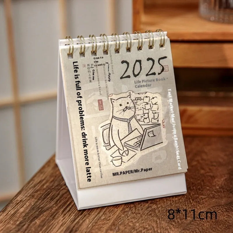 2025 mini desk calendar showing one of four designs: Coffee Time, Awake Time, Corner Perching, or Afternoon Lazy.