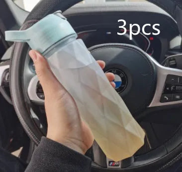 Large plastic spray water bottle with handle strap and leakproof lid in green colour.