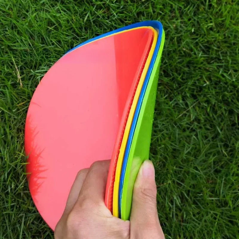 Soft yellow TPE football landmark pad disc on grass, 23 cm diameter.