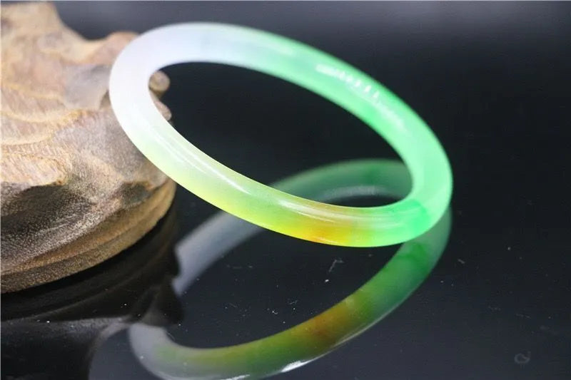 Jade bracelet with floating flower patterns and auspicious cloud motifs in green stone with polished finish